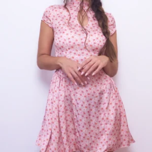 Angled front view of the pink floral Ayris mini dress with a fitted waist and full gathered side skirt panels.