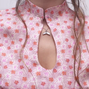 Close-up of the Mandarin collar and teardrop-shaped keyhole neckline on the pink floral Ayris dress.