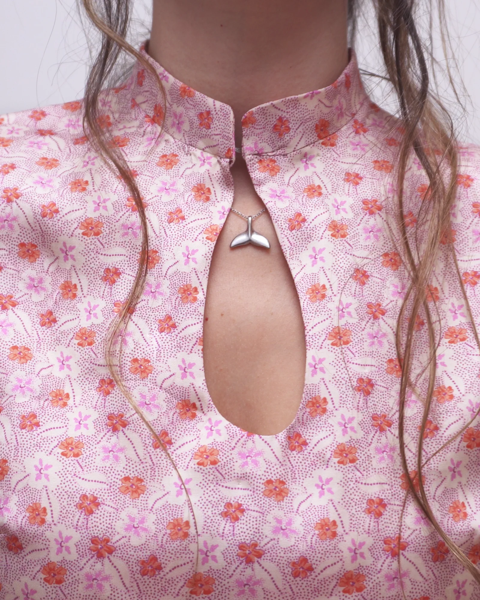 Close-up of the Mandarin collar and teardrop-shaped keyhole neckline on the pink floral Ayris dress.