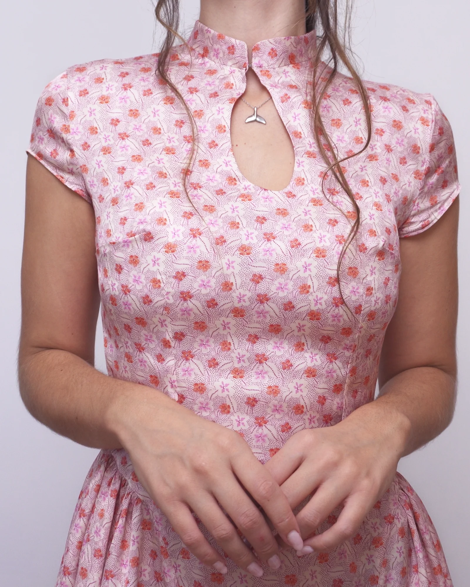 Pink floral Ayris dress with a Mandarin collar, keyhole neckline, short sleeves and fitted bodice.