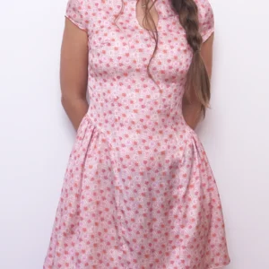 Angled view of the pink floral Ayris mini dress with gathered side panels and a fitted waist.